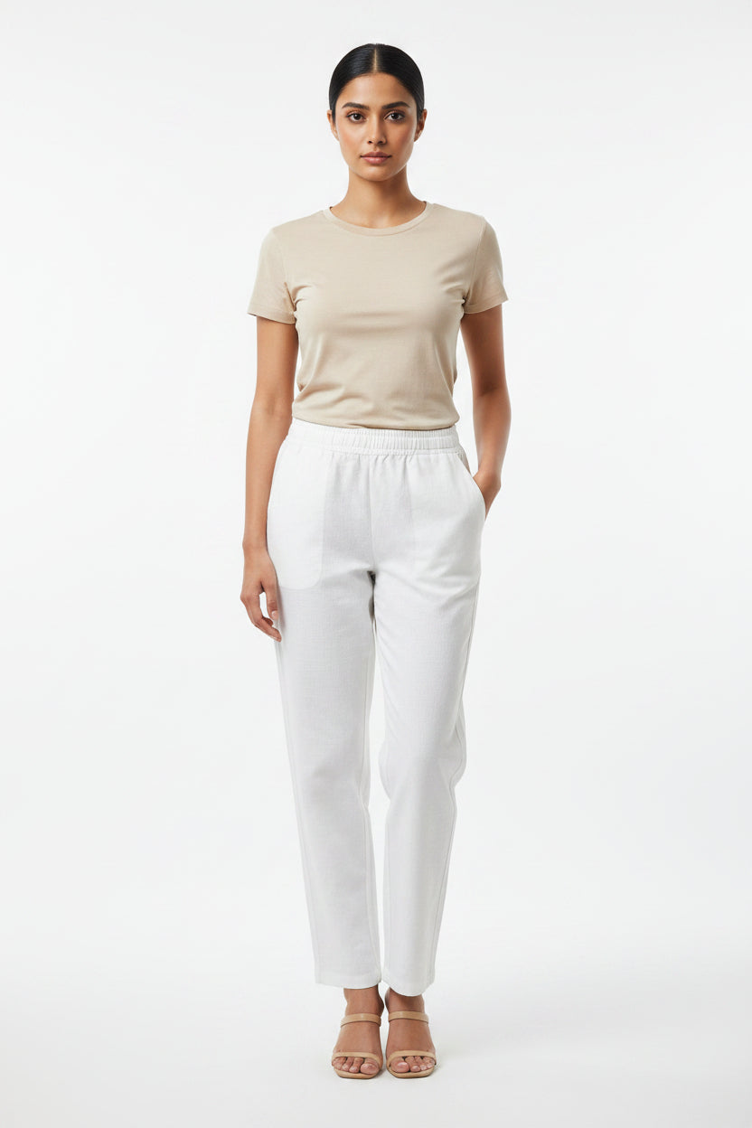 White casual pants featuring an elastic waistband and side pockets.