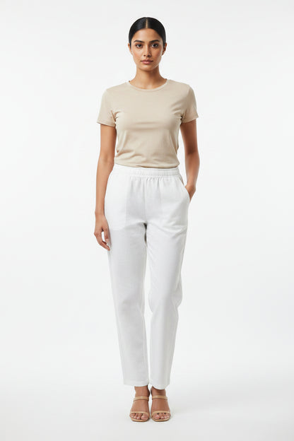 White casual pants featuring an elastic waistband and side pockets.