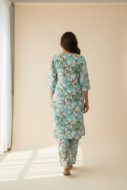 A woman wearing a turquoise floral kurta and matching pants.