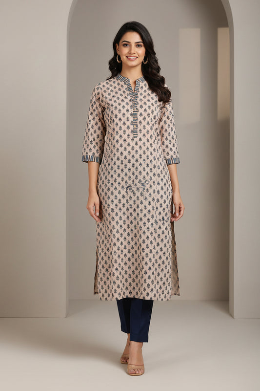 A beige cotton kurta with a black geometric pattern and striped ruffle trim, laid flat on a bright green background.