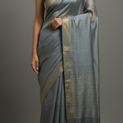 Gray saree with gold border draped over a person on a gray background