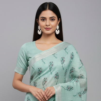Woman wearing a light green saree with a subtle floral pattern on a gray background