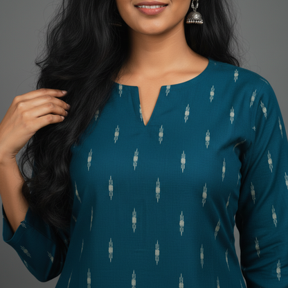 Woman wearing a teal dress with a subtle pattern against a gray background